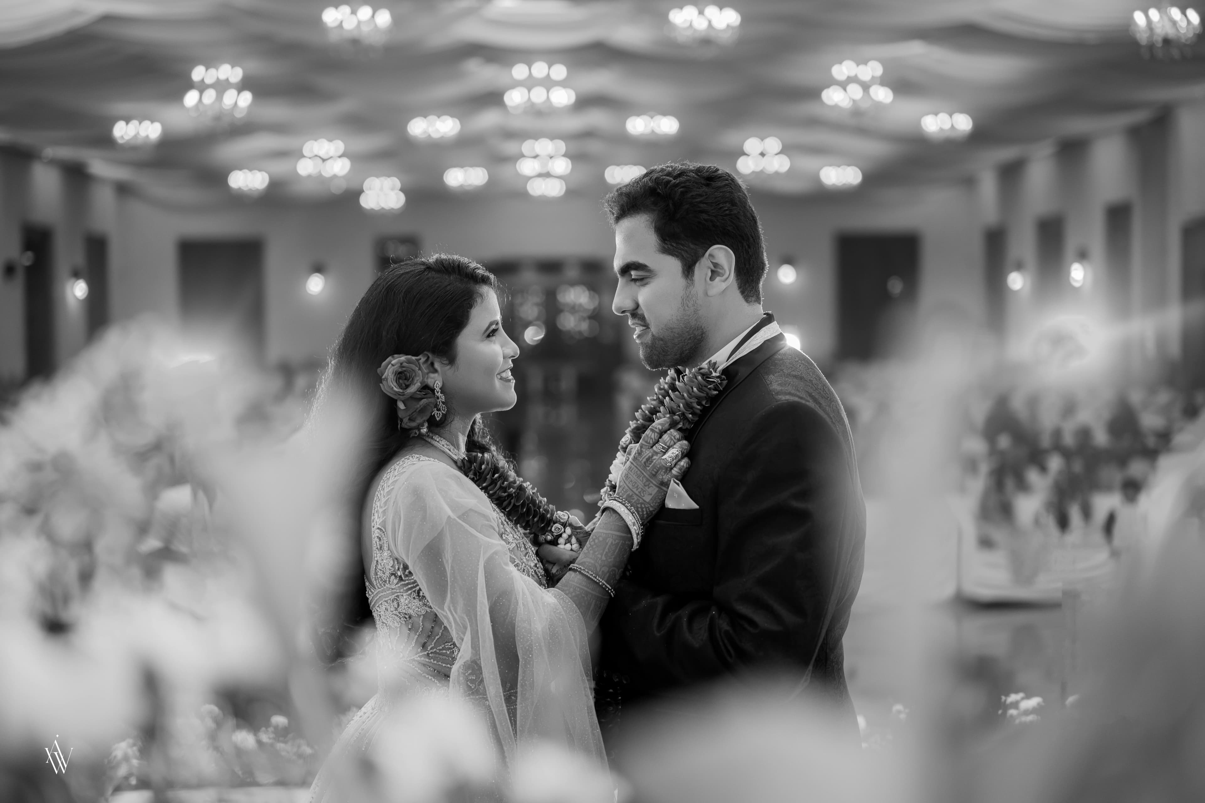 A wedding couple beneath celebration lights
